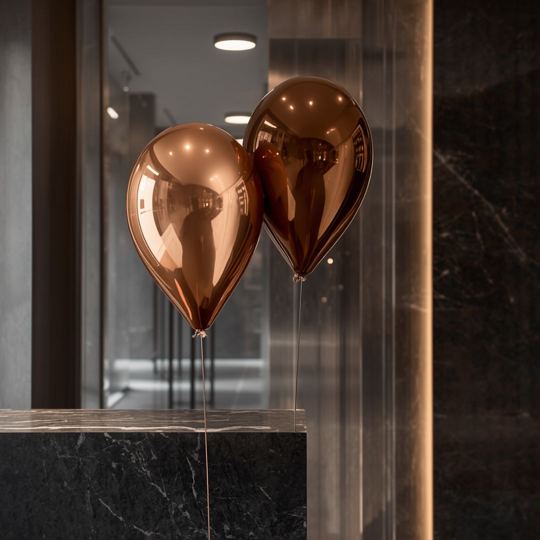 Atlore metallic copper and bronze balloons decorating a dark stone counter for a luxury jewelry launch event.