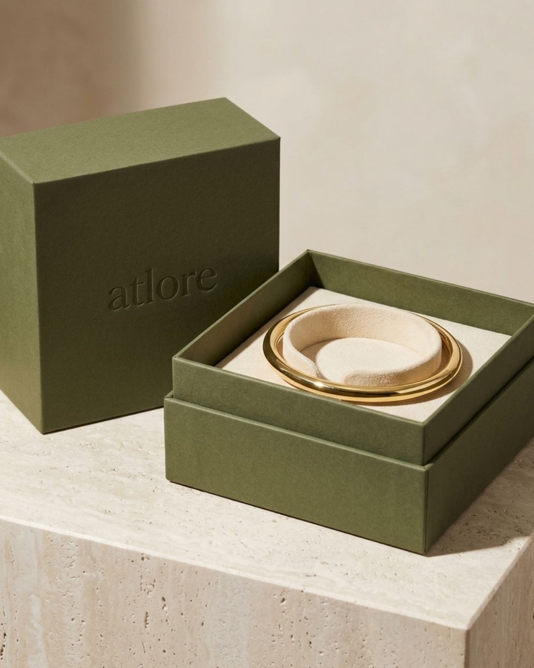 Wholesale deep-profile olive green paper 2-piece bangle packaging box with a round cream suede cushion insert by Atlore.