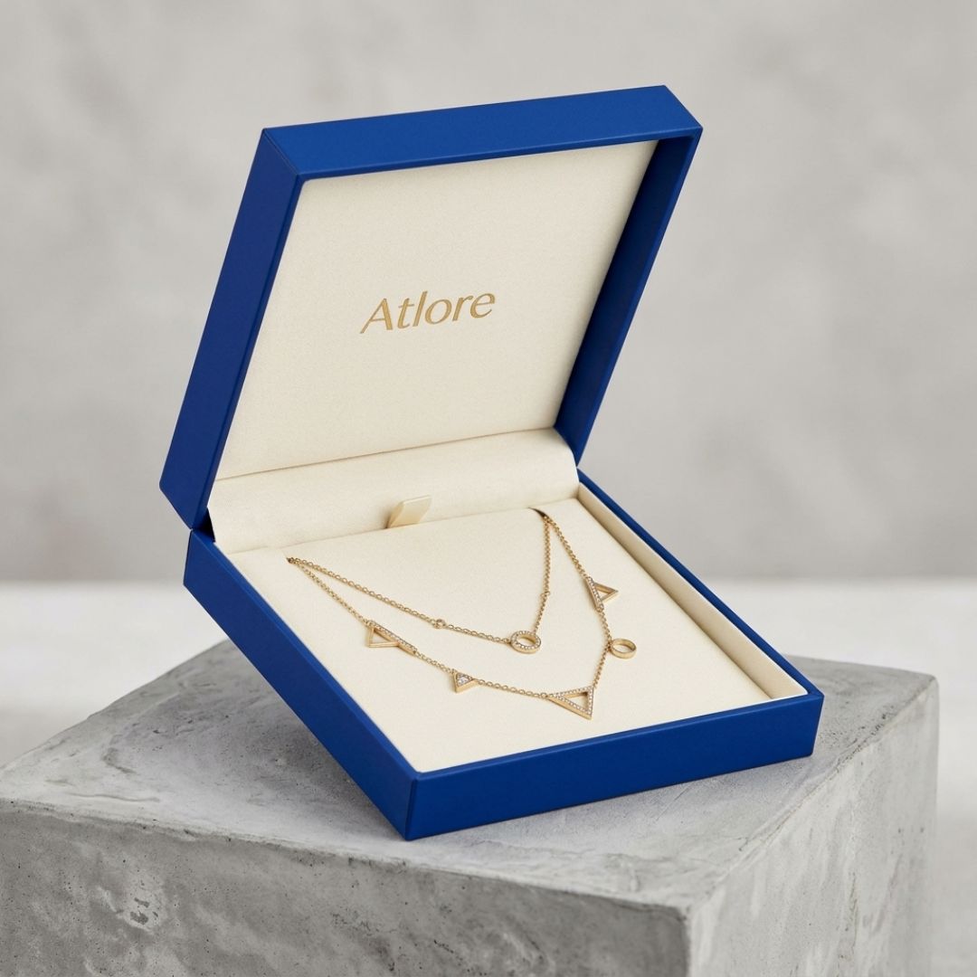  Rigid cobalt blue paper-plastic hinged necklace packaging box featuring a custom cream pigpell lined interior pad.