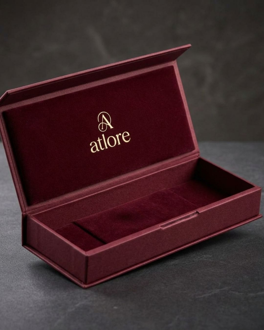  Rigid deep maroon paper magnetic box with a matching maroon velvet inner display pad by Atlore.